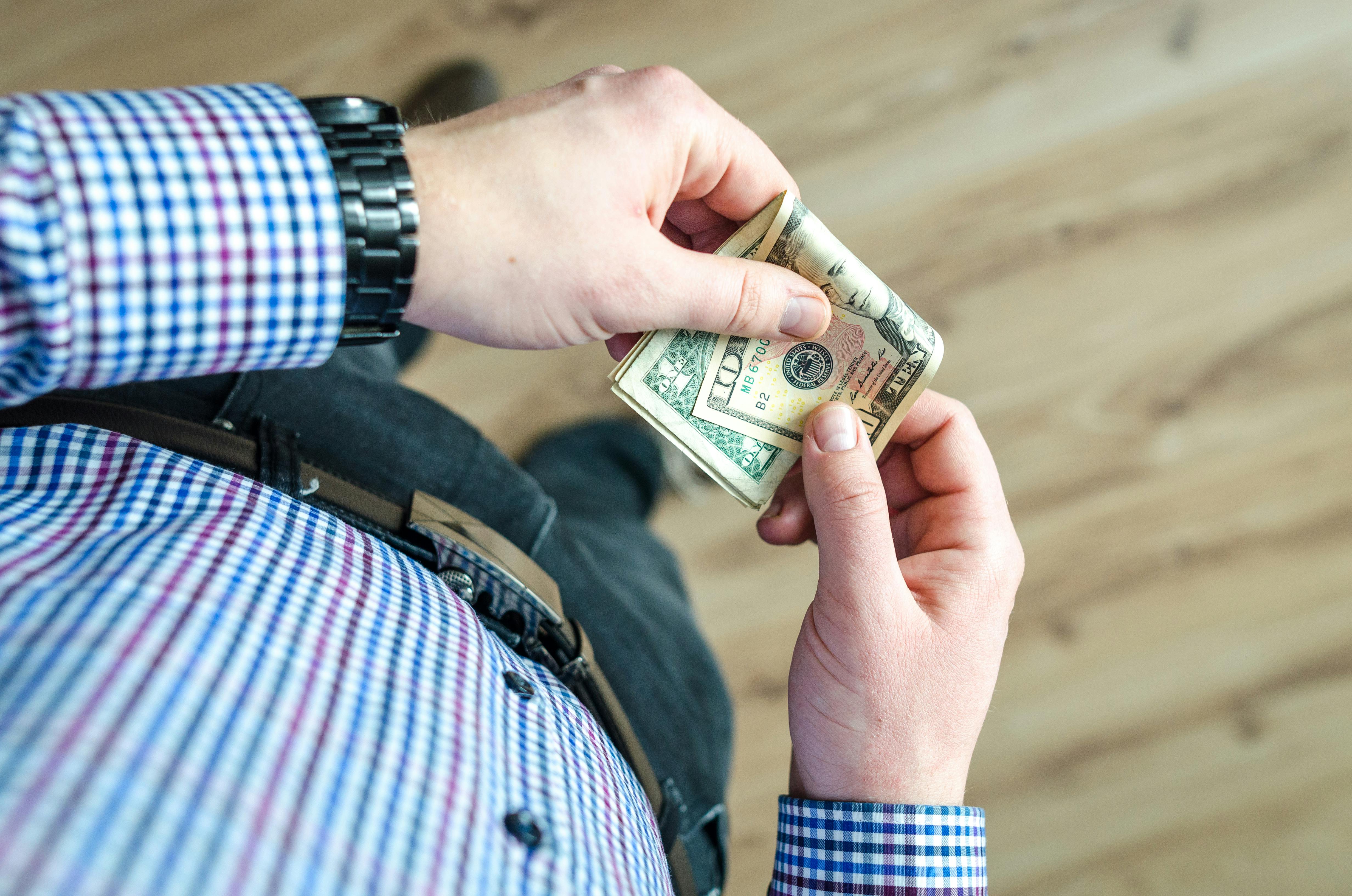 person holding one and ten dollar bills